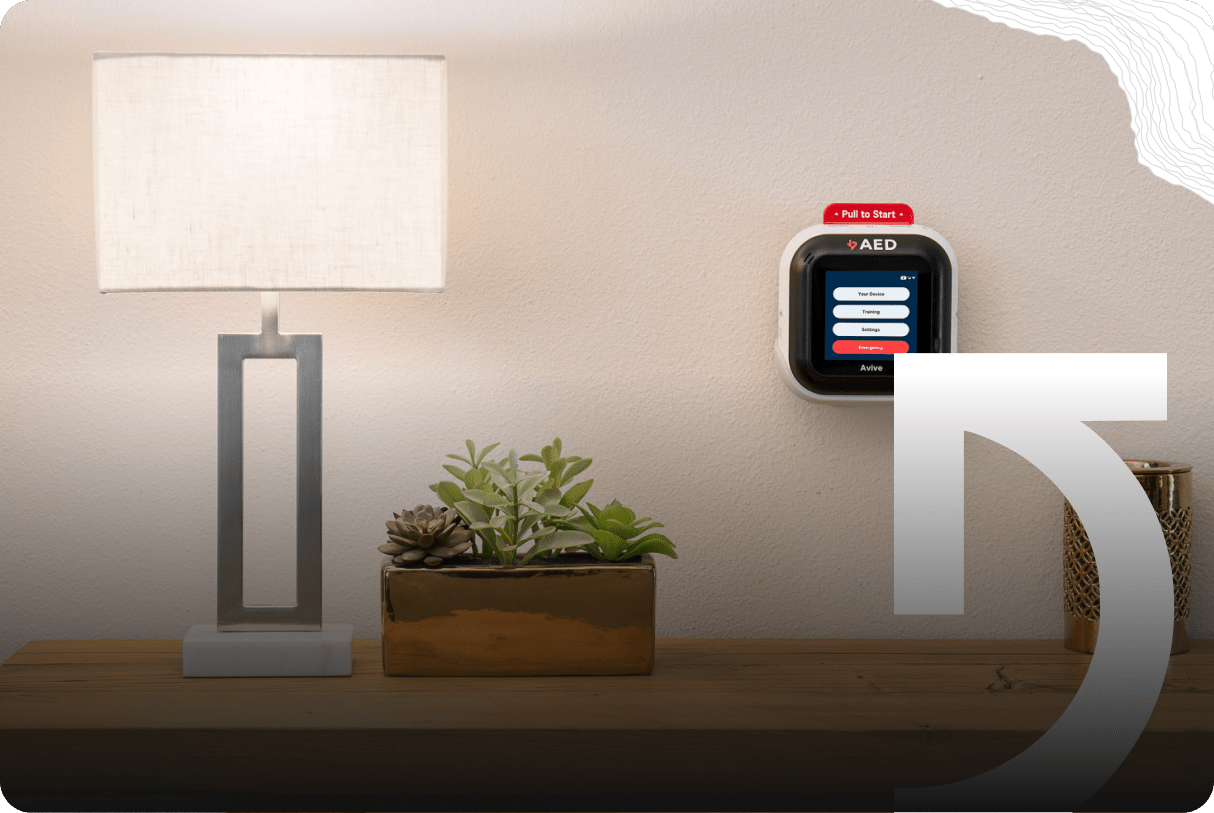 A table lamp and a rectangular planter with succulents sit on a wooden surface next to an AED device mounted on a wall, setting the scene for everyday success stories.
